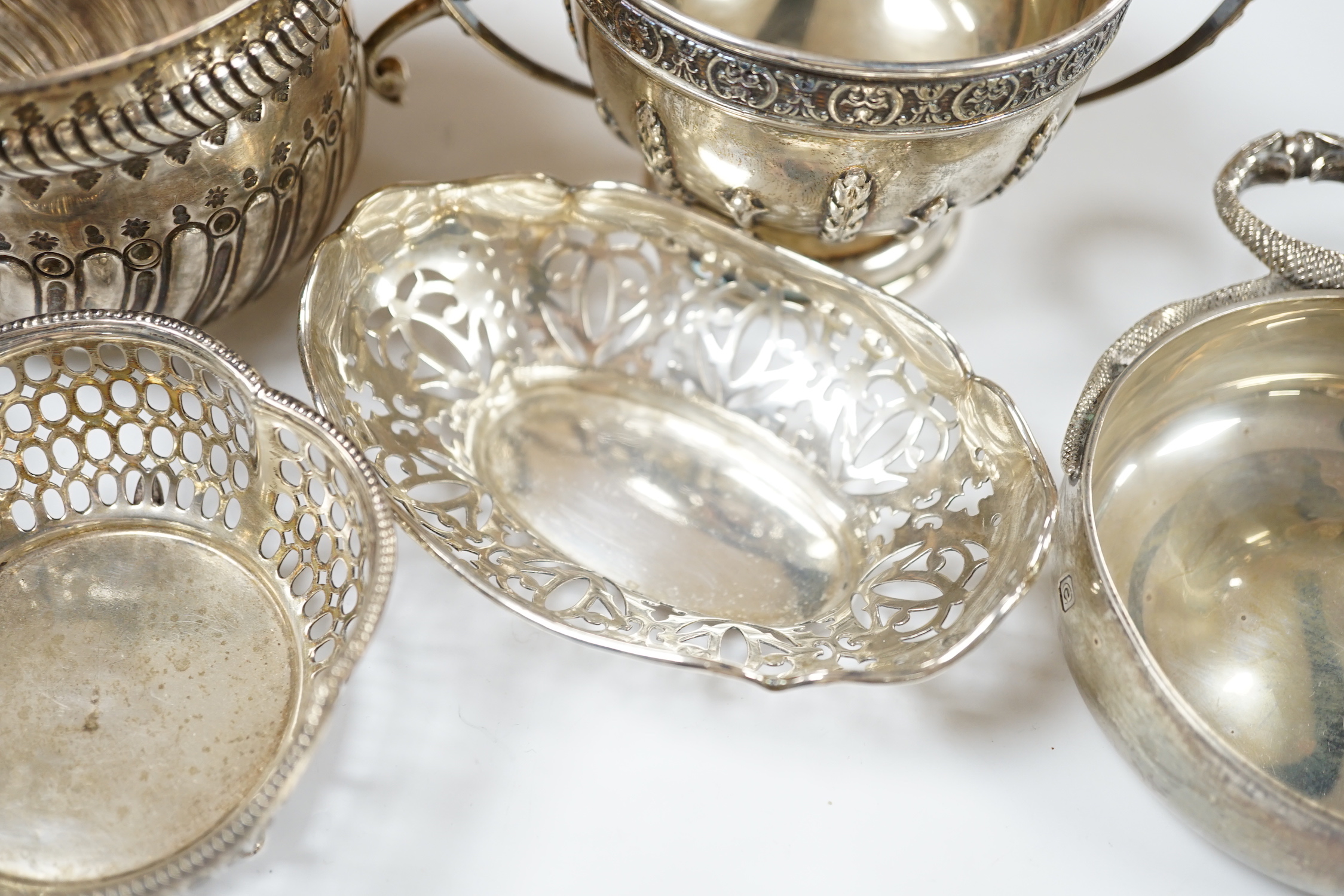 An Edwardian repousse silver porringer, Daniel & John Welby, London, 1905, diameter 92mm, a pair of pierced silver bonbon dishes, one other similar bonbon dish, a silver two handled bowl and a modern silver taste vin